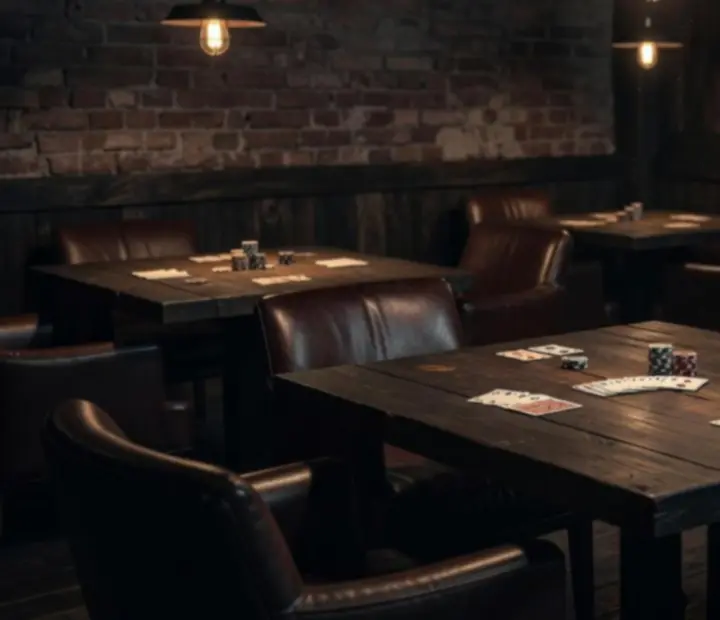 Upstairs Cleaver Room card lounge with intimate lighting and card tables